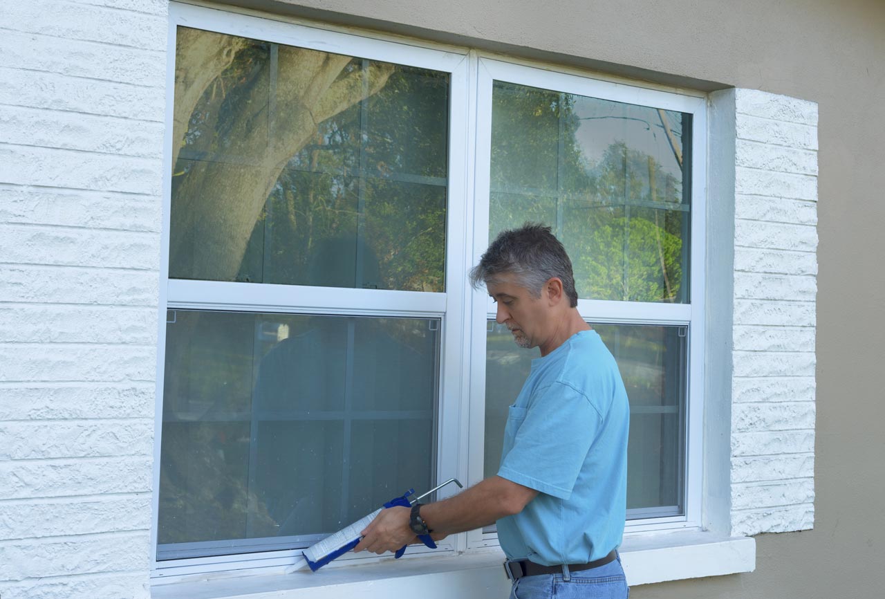 A skilled worker doing window installation using a power hand drill