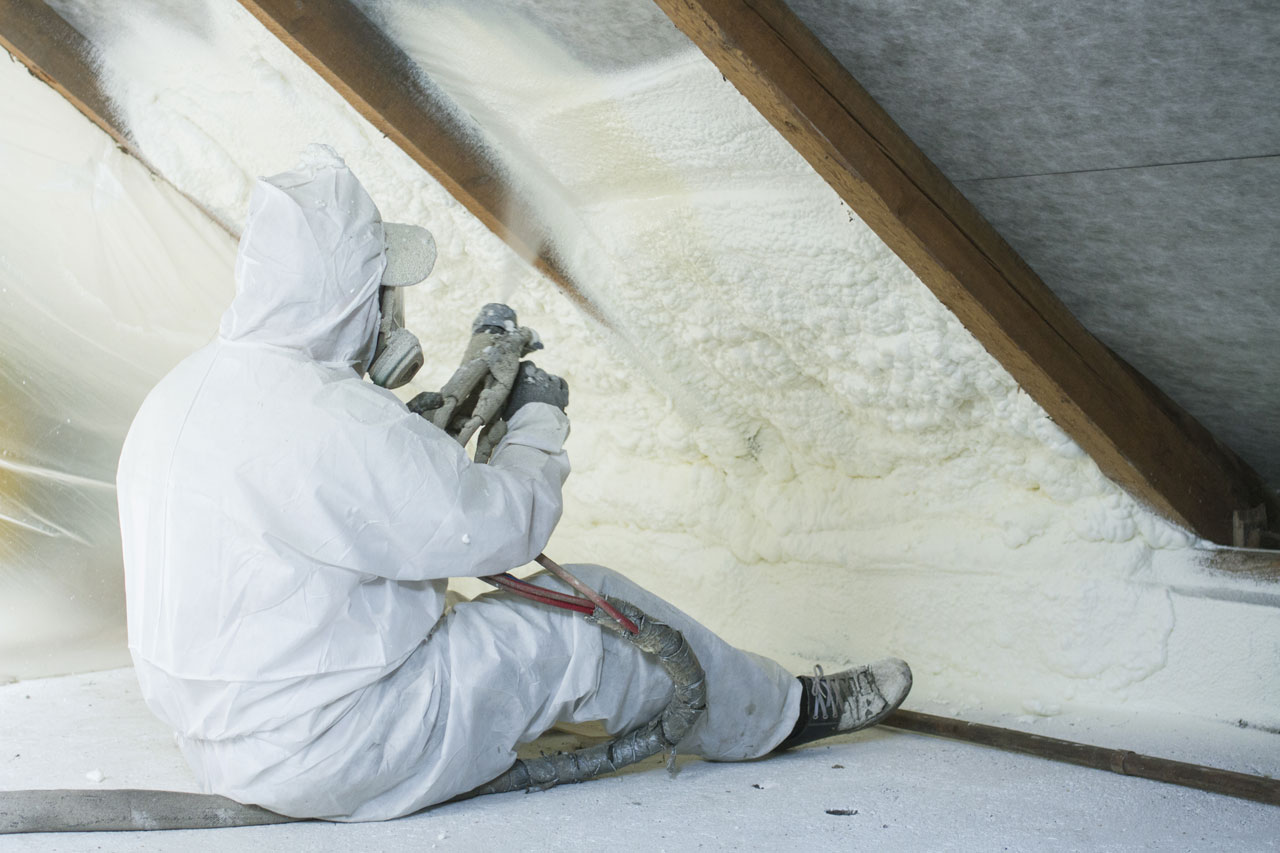 A professional performing weatherization service, spray foam insulation, on the house interior for added protection